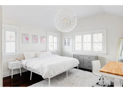 a bedroom with a bed and a table in it with window