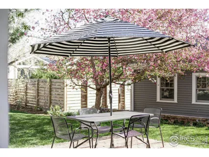 a patio with table and chairs and potted plants