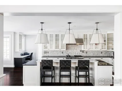 a kitchen with kitchen island granite countertop a table chairs sink and cabinets