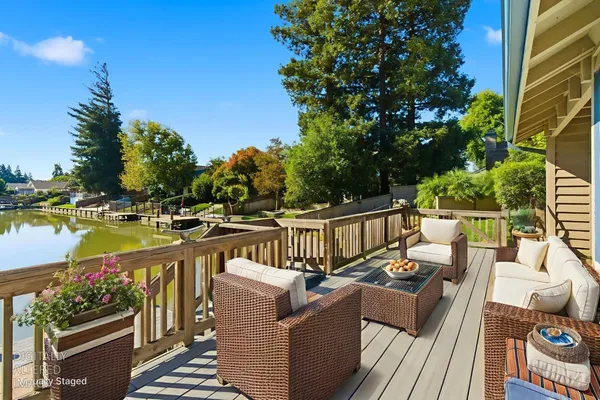 a view of a balcony with wooden floor and outdoor seating
