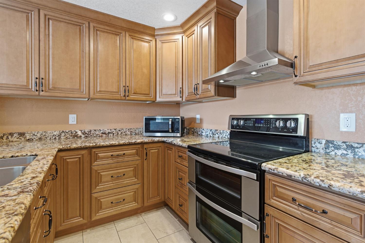 7348 Lighthouse Drive Stockton, CA 95219 - Photo 23 of 56 a kitchen with stainless steel appliances granite countertop a stove and a sink