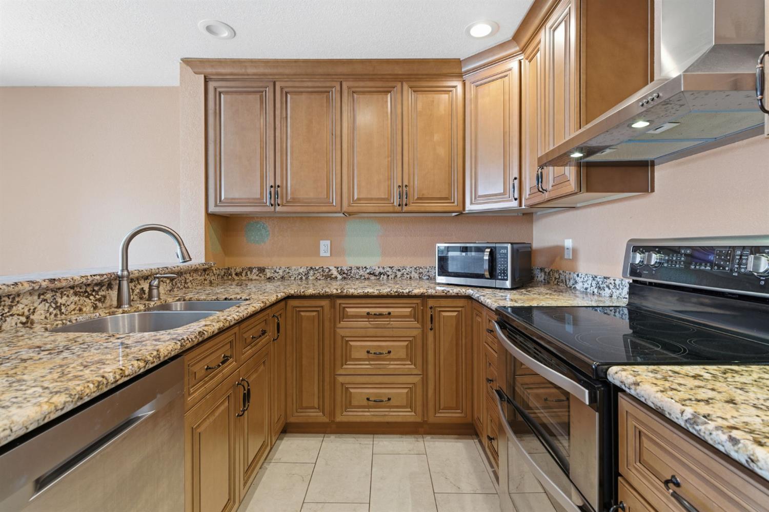 7348 Lighthouse Drive Stockton, CA 95219 - Photo 24 of 56 a kitchen with stainless steel appliances granite countertop a stove sink and cabinets