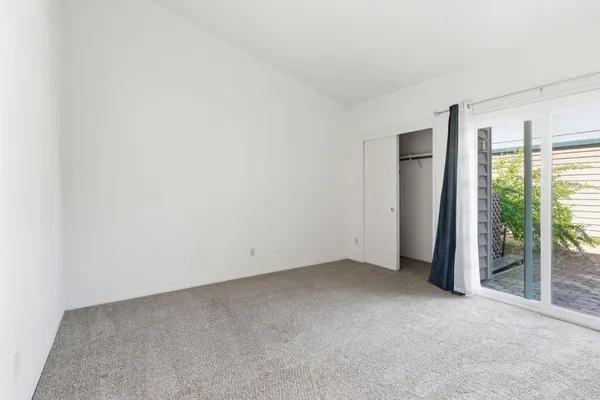an empty room with windows and fireplace