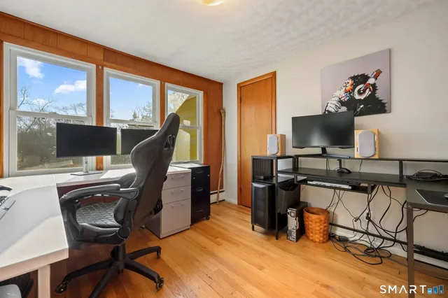 a view of a workspace with furniture and a window