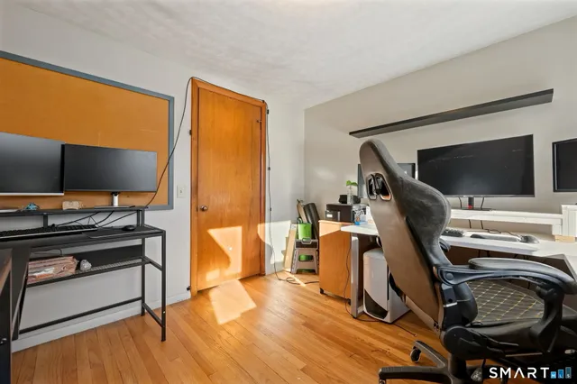 a view of a workspace with furniture and a flat screen tv