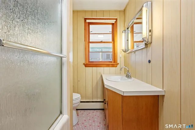 a bathroom with a sink a toilet and shower