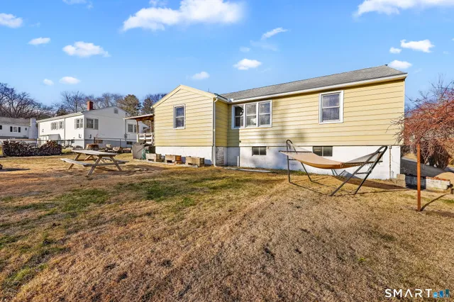 a view of a house with a yard and wooden fence