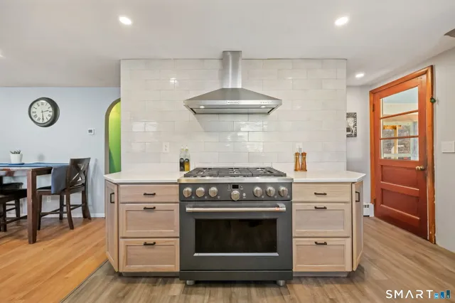 a kitchen with stainless steel appliances a stove and a chandelier