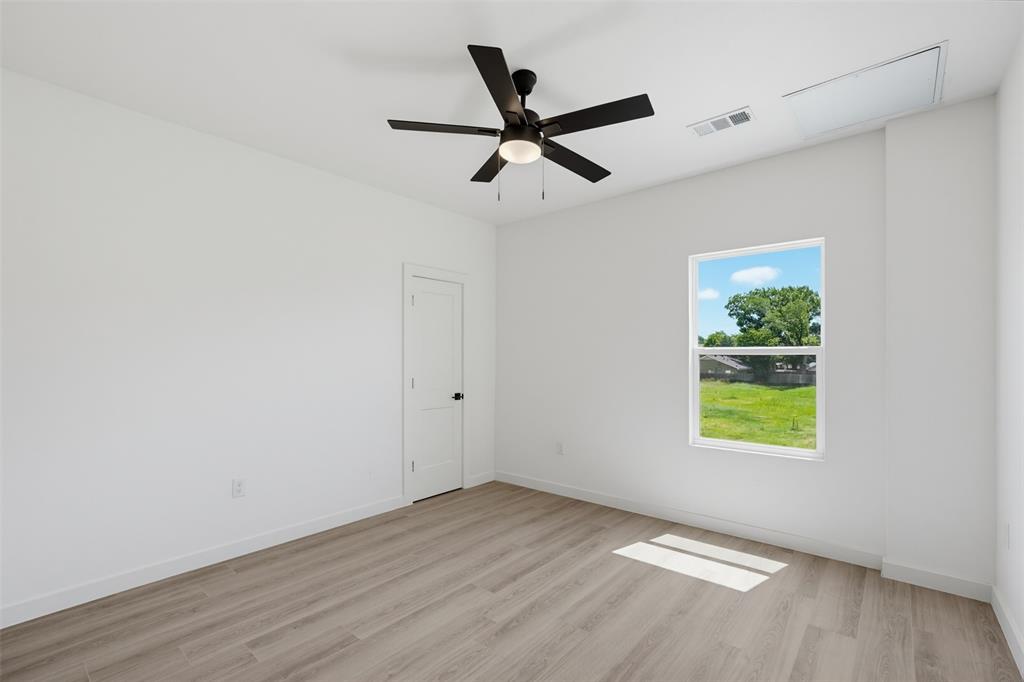 516 South O Connor Road Irving, TX 75060 - Photo 9 of 23 Room featuring wood-finish flooring, a contemporary ceiling fan with integrated lighting, white walls, and a white interior door
