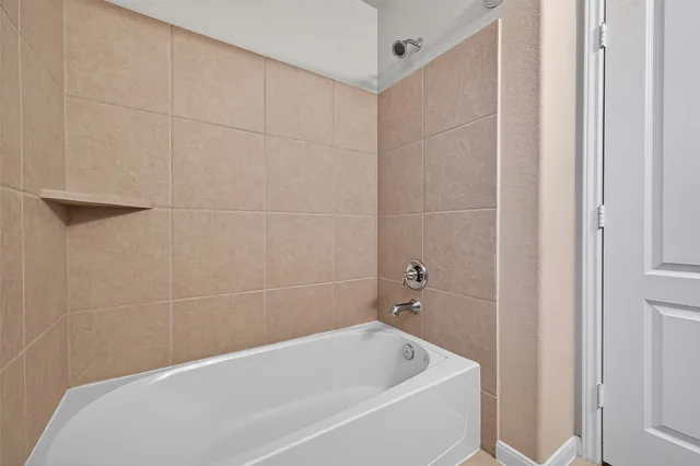 an empty room with chandelier fan and windows