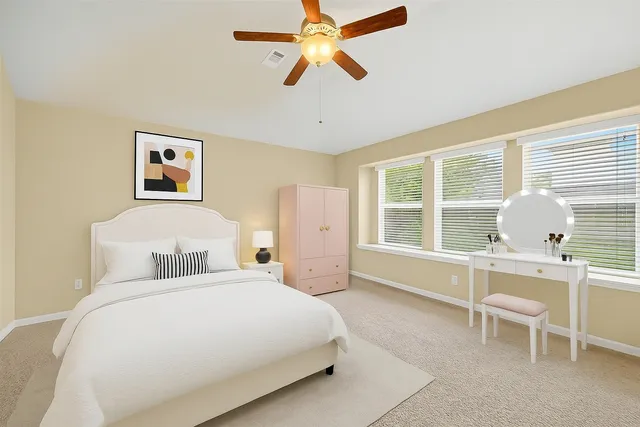 a bedroom with a bed and a ceiling fan