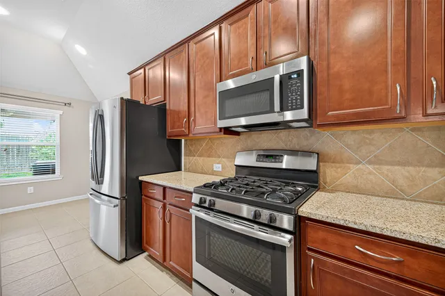 a large kitchen with stainless steel appliances granite countertop a stove and a sink