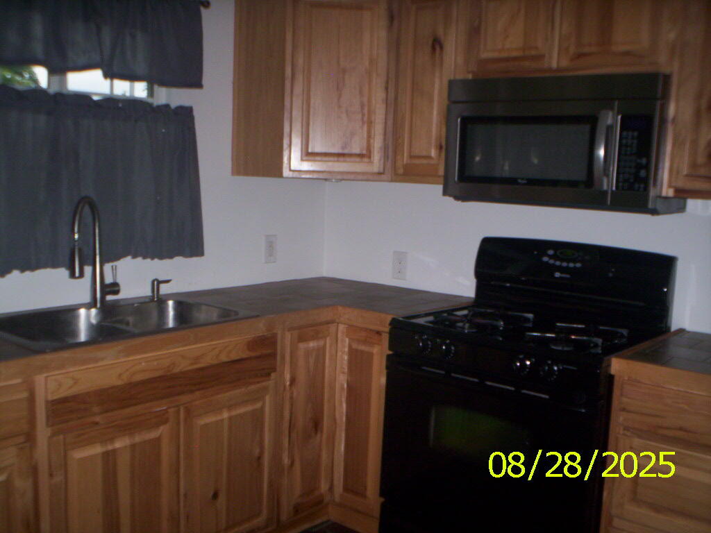 121 South Wisconsin Street Hobart, IN 46342 - Photo 6 of 7 a kitchen with granite countertop a sink stainless steel appliances and cabinets