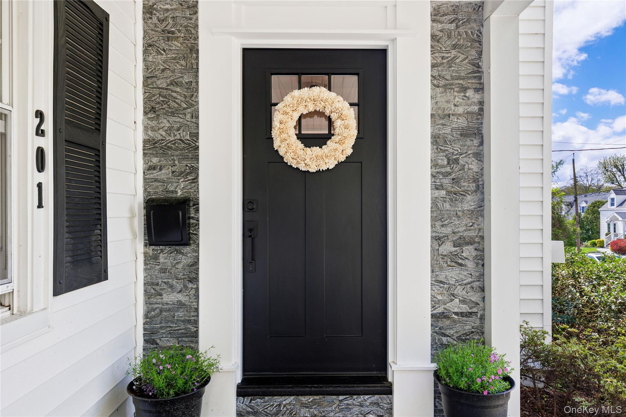 201 Clayton Road Scarsdale, NY 10583 - Photo 3 of 34 Custom, hand-cut stonework frames the front door.