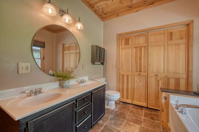 514 Browns Cove Road Blue Ridge, GA 30513 - Photo 26 of 77 a bathroom with a granite countertop sink toilet a mirror and vanity