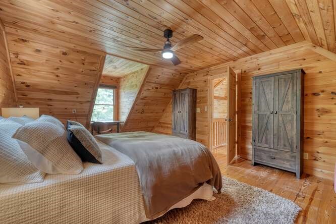 514 Browns Cove Road Blue Ridge, GA 30513 - Photo 31 of 77 a bedroom with a bed and a chandelier