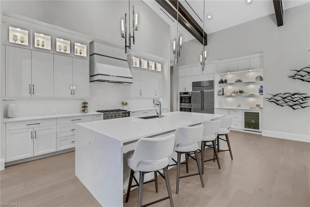 12 Banyan Road Naples, FL 34108 - Photo 13 of 50 a kitchen with cabinets a sink and chairs