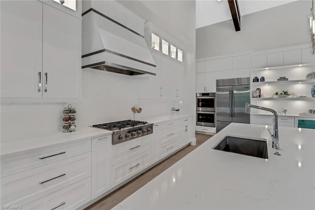 12 Banyan Road Naples, FL 34108 - Photo 14 of 50 a kitchen with stainless steel appliances kitchen island wooden cabinets and a refrigerator