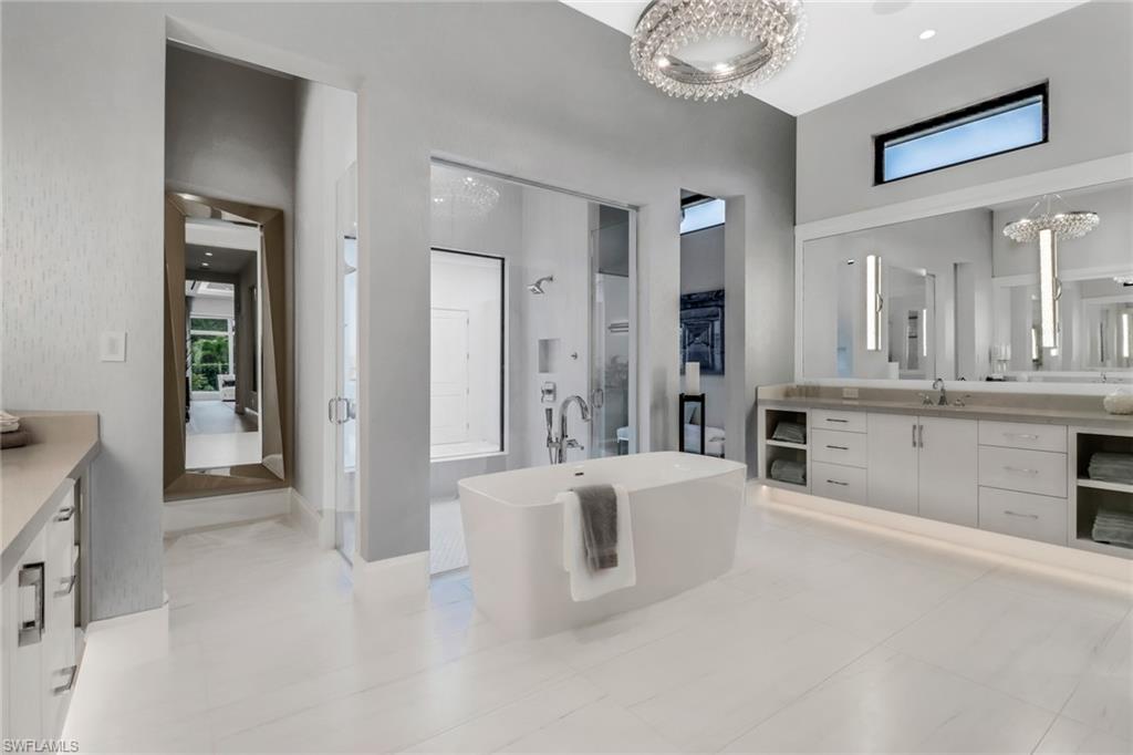 12 Banyan Road Naples, FL 34108 - Photo 22 of 50 a large en suite bathroom with a tub double vanity and mirrors