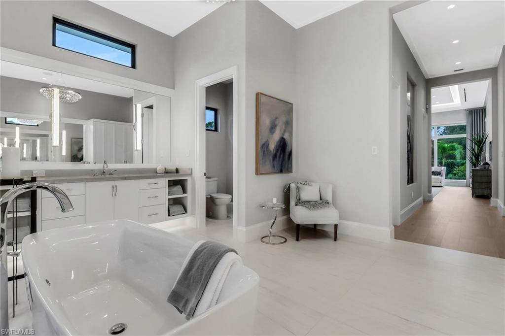 12 Banyan Road Naples, FL 34108 - Photo 24 of 50 a living room with furniture and a large mirror