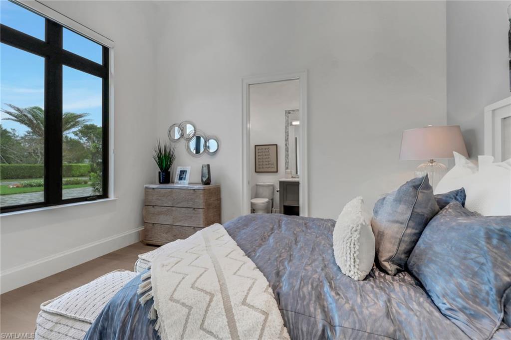 12 Banyan Road Naples, FL 34108 - Photo 27 of 50 a bedroom with a bed and a large window