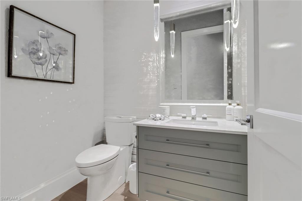 12 Banyan Road Naples, FL 34108 - Photo 36 of 50 a bathroom with a toilet a sink and mirror