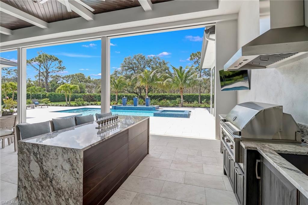 12 Banyan Road Naples, FL 34108 - Photo 41 of 50 a living room with large furniture and a floor to ceiling window