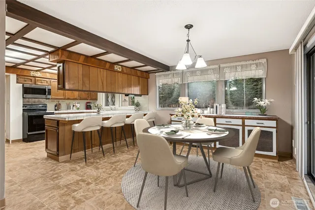 a dining room with wooden floor a chandelier a wooden table and chairs