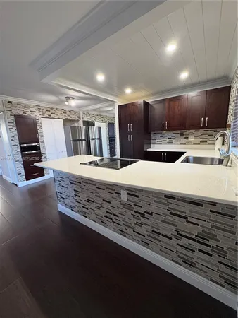 a large kitchen with kitchen island a sink stainless steel appliances and cabinets