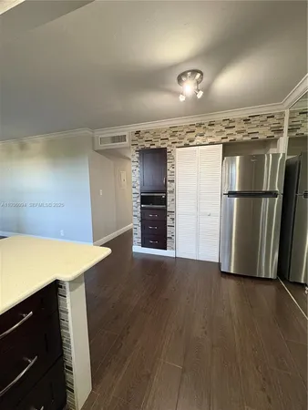 a kitchen with a refrigerator and a stove top oven