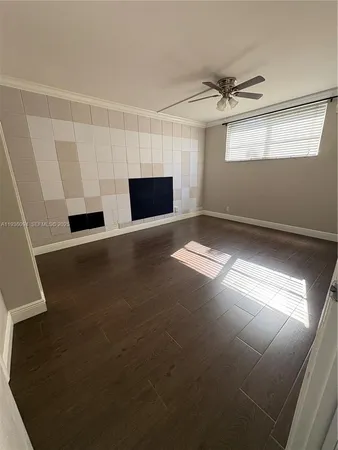a view of an empty room with a fireplace and a window