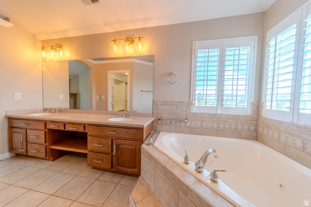 598 Hollow Creek Road Draper, UT 84020 - Photo 95 of 110 Spacious bathroom featuring a built-in soaking tub with surrounding tile, plantation shutters, and a double vanity with ample storage