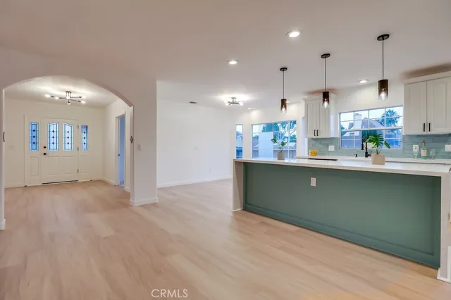 a living room with furniture a dining table and chairs with wooden floor