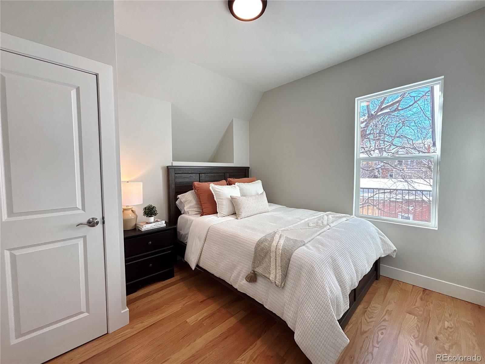 1129 Fillmore Street Denver, CO 80206 - Photo 15 of 32 a bedroom with a bed and wooden floor