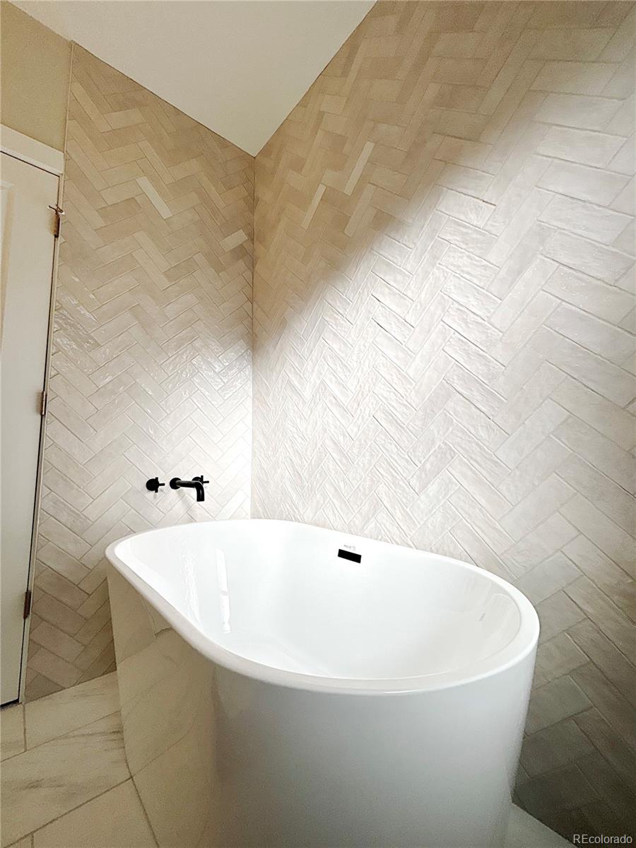 1129 Fillmore Street Denver, CO 80206 - Photo 17 of 32 a white bath tub sitting in a bathroom