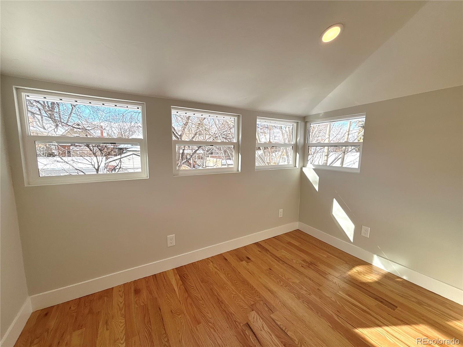 1129 Fillmore Street Denver, CO 80206 - Photo 21 of 32 a view of empty room with wooden floor and fan