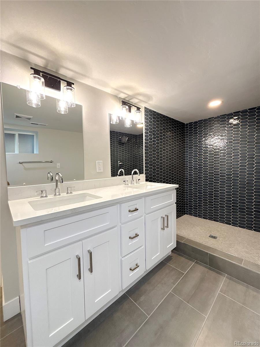 1129 Fillmore Street Denver, CO 80206 - Photo 25 of 32 a bathroom with a double vanity sink and mirror with bathtub