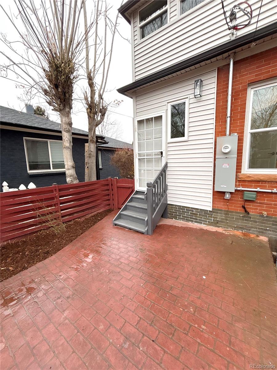 1129 Fillmore Street Denver, CO 80206 - Photo 32 of 32 a backyard of a house with barbeque oven and brick wall