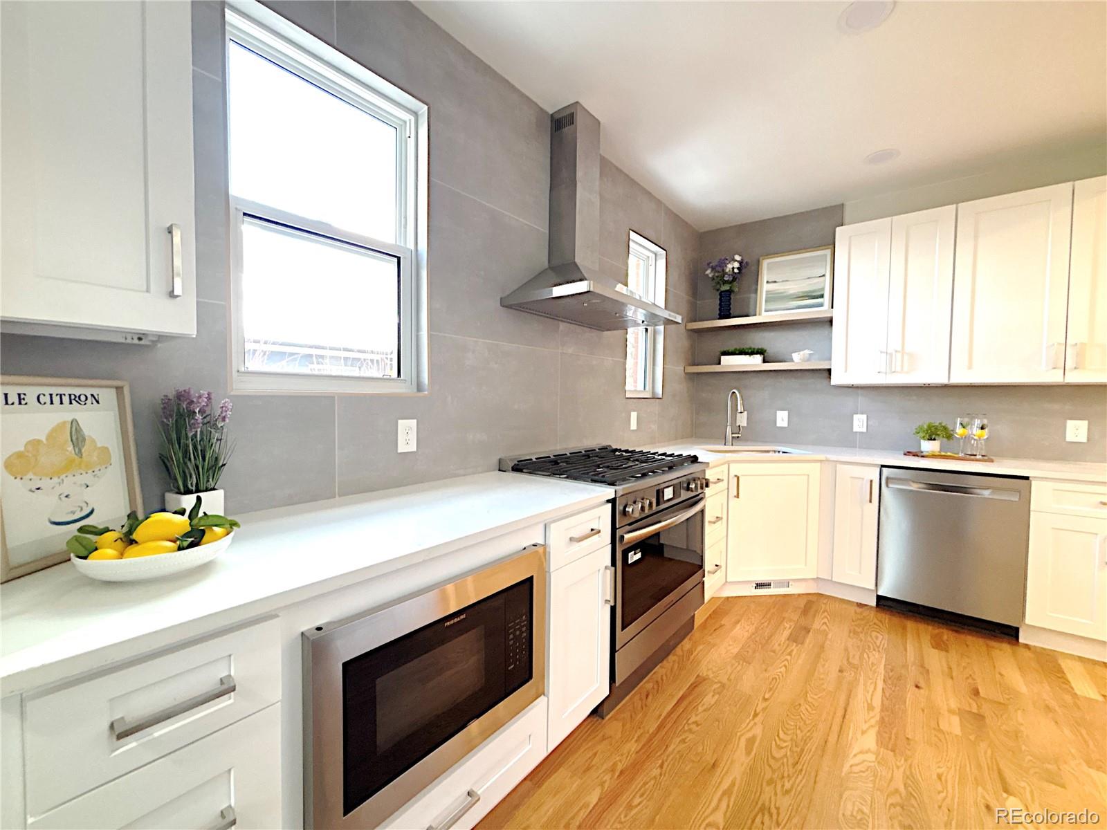 1129 Fillmore Street Denver, CO 80206 - Photo 7 of 32 a kitchen with a stove a sink and a microwave