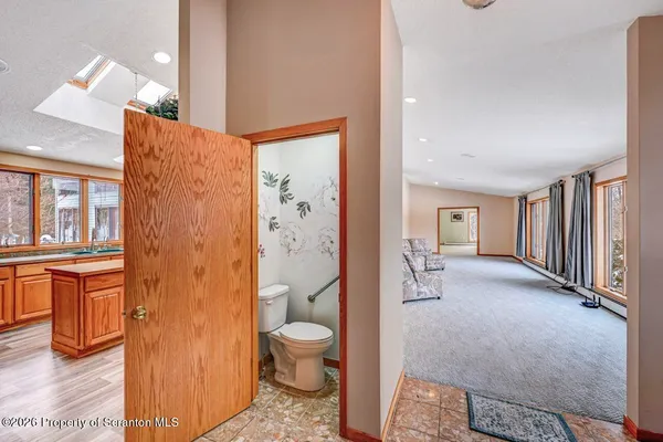 a living room with stainless steel appliances furniture and a kitchen view