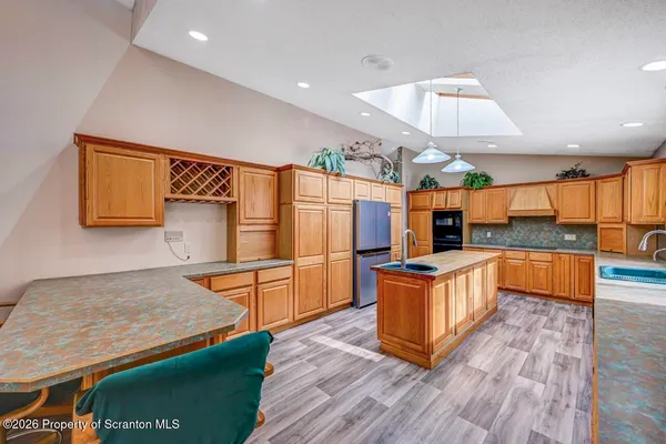 a kitchen with granite countertop wooden cabinets and stainless steel appliances