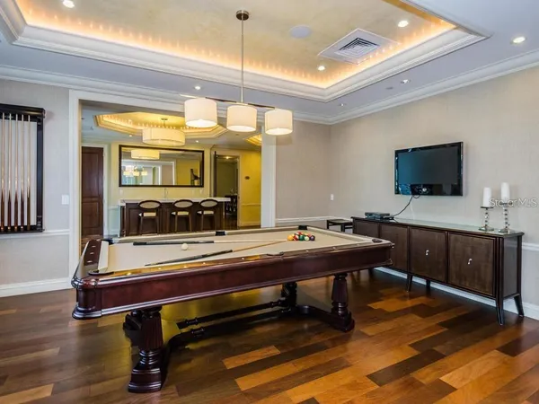 a room with furniture pool table flat screen tv and a table