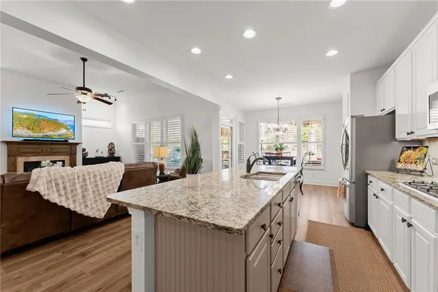 a kitchen with granite countertop a sink a counter top space stainless steel appliances and cabinets