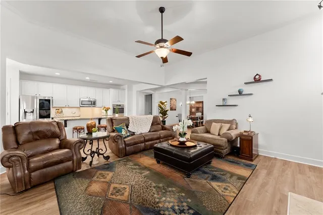 a living room with furniture a chandelier and a rug
