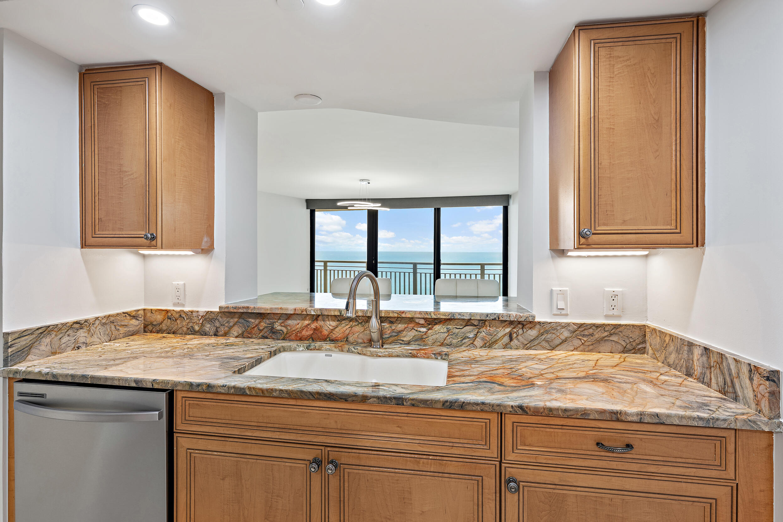 3000 North Ocean Drive, Unit 17D Riviera Beach, FL 33404 - Photo 8 of 34 a kitchen with granite countertop cabinets sink and window