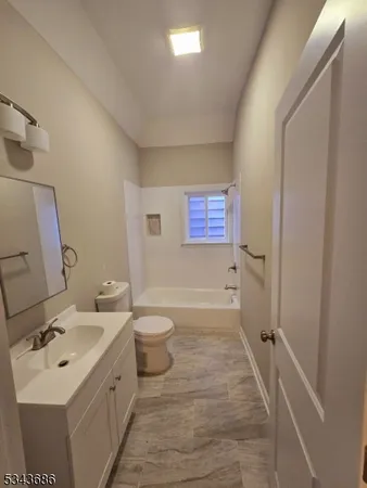 a bathroom with a sink and mirror with toilet