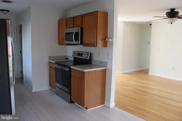 an empty room with wooden floor and a ceiling fan