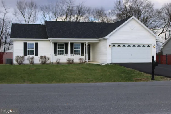 a front view of a house with a garden and plants