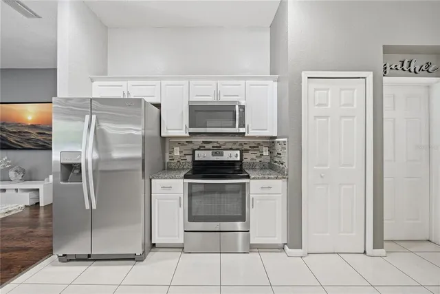 a kitchen with stainless steel appliances granite countertop a refrigerator and a stove top oven