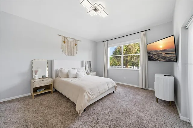 a bedroom with a bed and a flat tv screen on dresser
